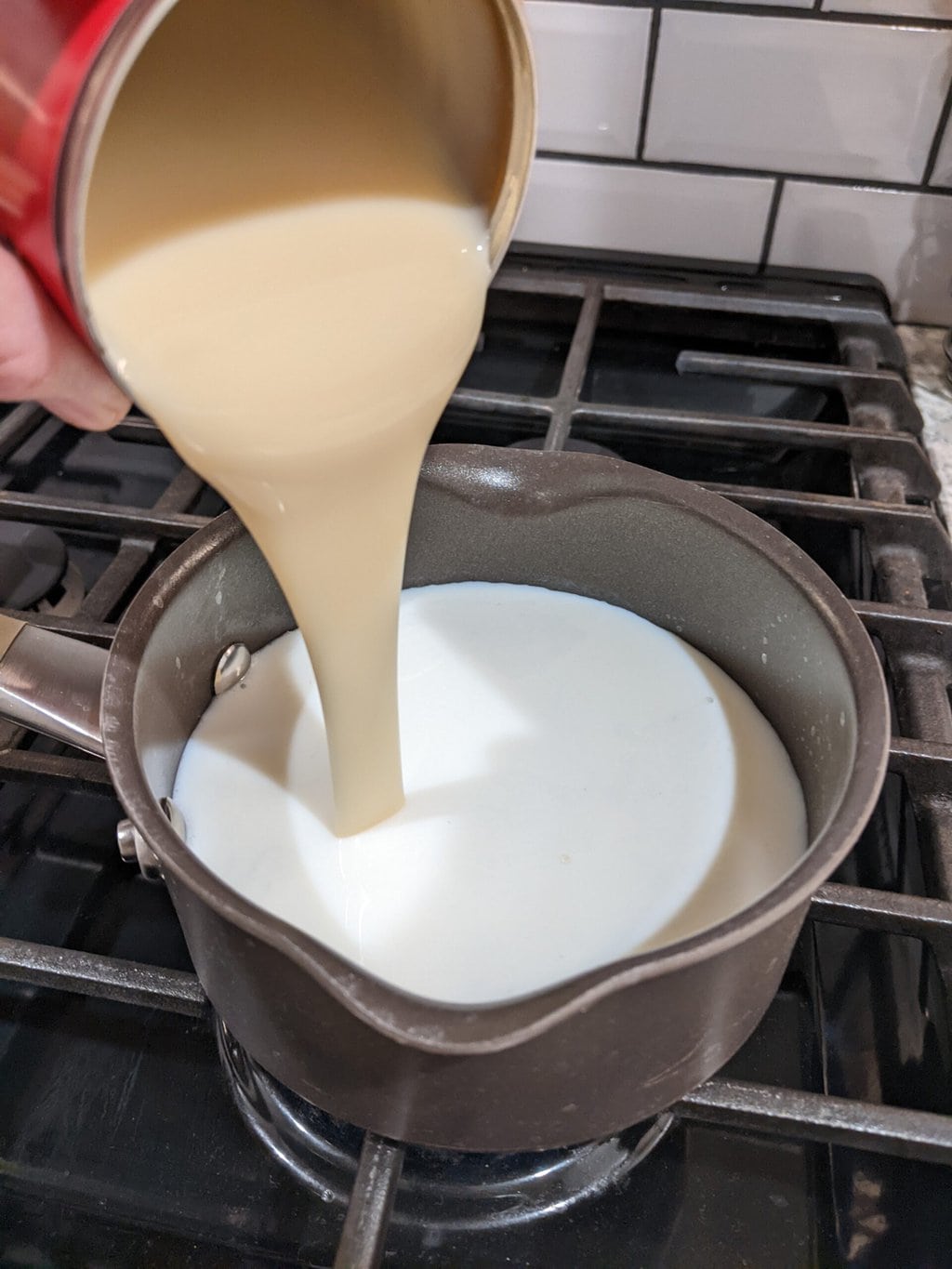 压缩牛奶加到炉子上的一碗牛奶