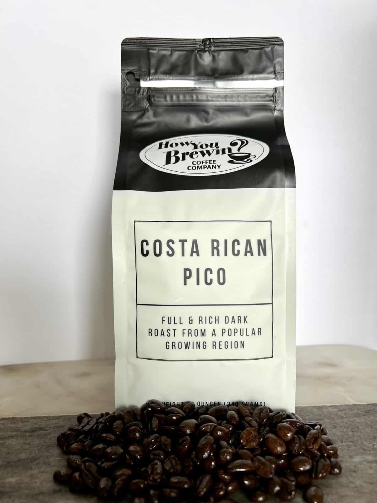 Costa-Rican-Pico-coffee-packaging-stands-on-coffee-beans-scaled
