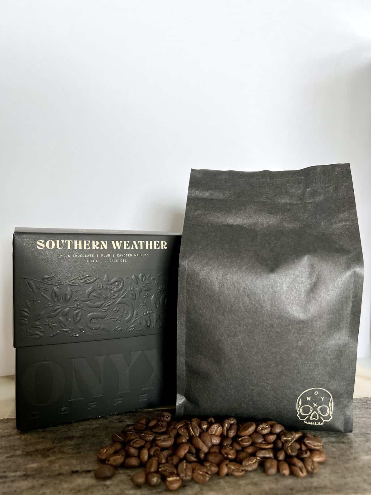 Onyx-Coffee-Lab-Southern-Weather-coffee-packaging-stands-on-coffee-beans-next-to-the-shipping-box-scaled