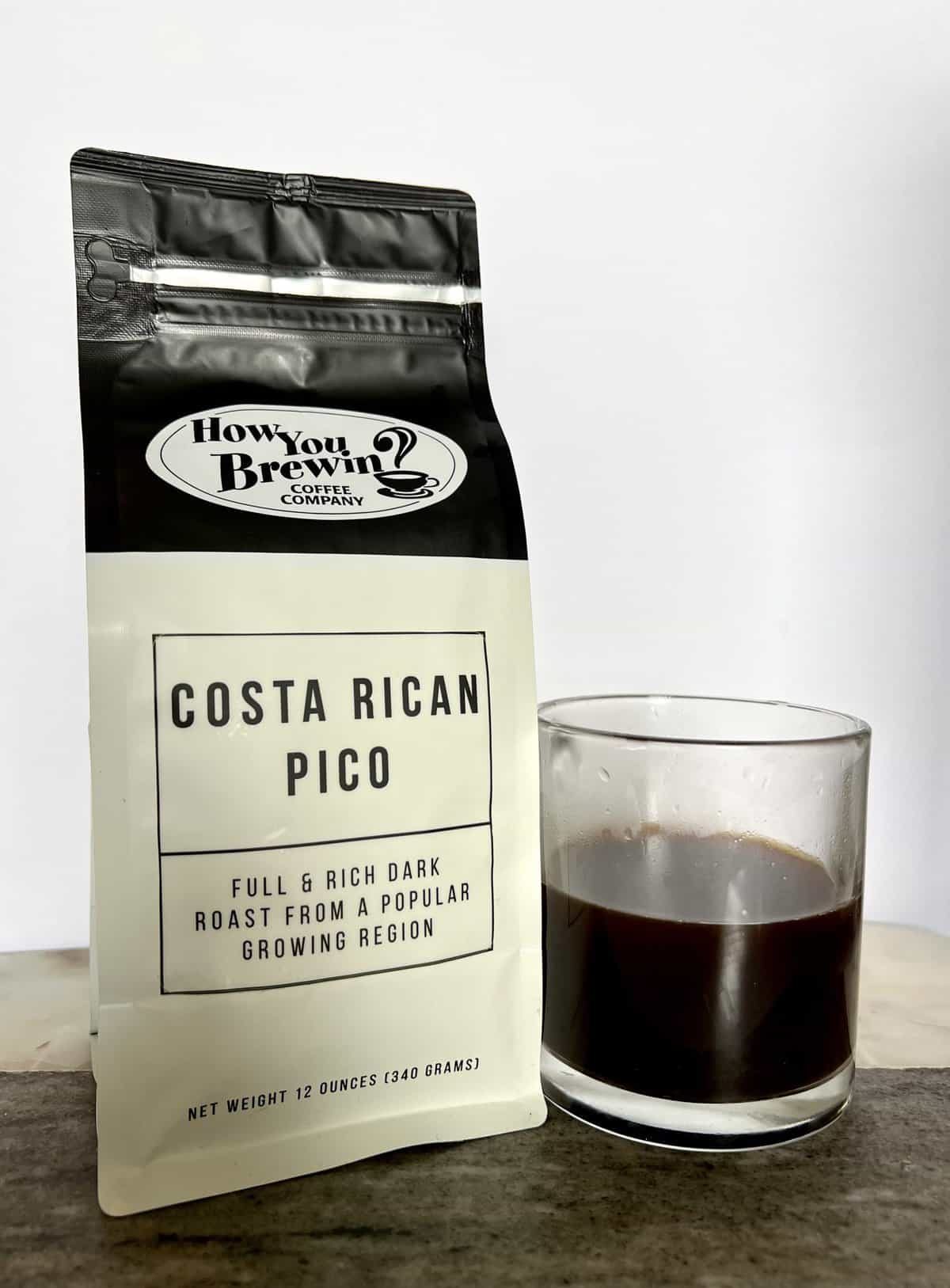 a-pack-of-Costa-Rican-Pico-coffee-stands-next-to-a-brewed-cup-of-coffee-scaled