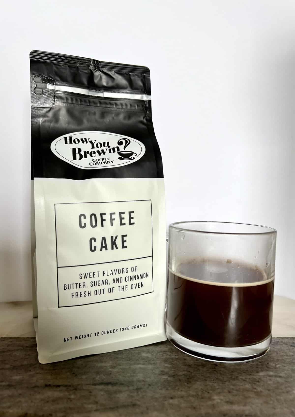 a-package-of-Coffee-Cake-coffee-stands-next-to-a-brewed-cup-of-coffee-scaled
