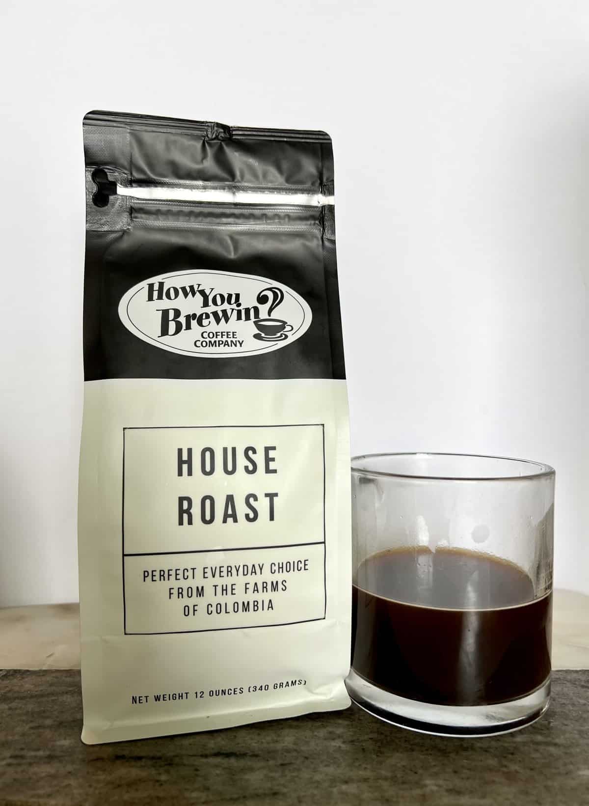 a-package-of-House-Roast-coffee-stands-next-to-a-brewed-cup-of-coffee-scaled