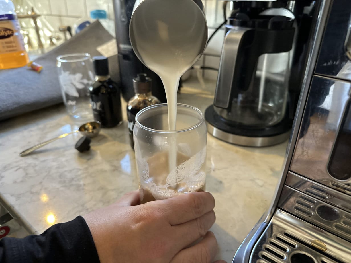 酿奶倒入杯子和Jot Ultra咖啡