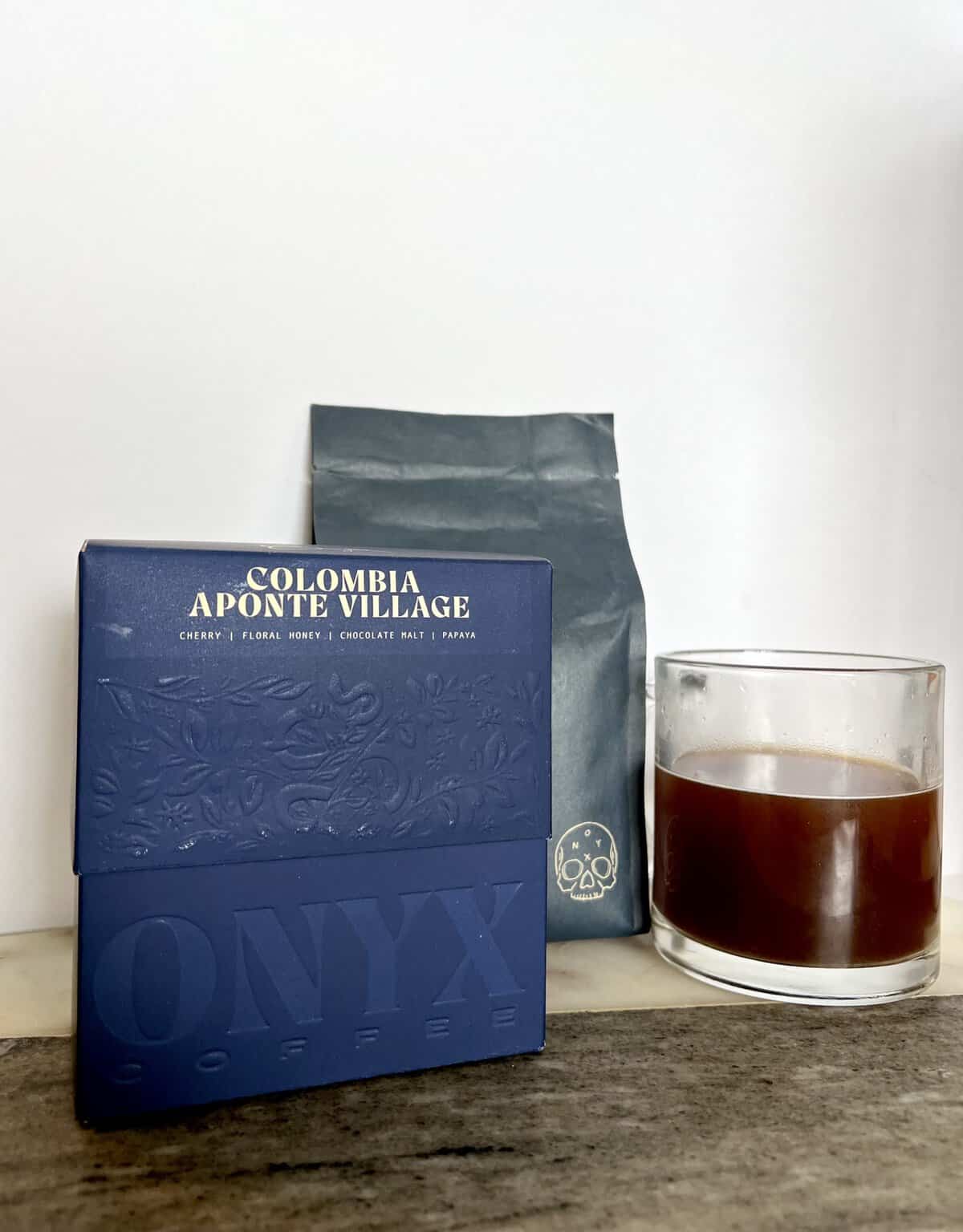 packaging-of-Onyx-Coffee-Lab-Colombia-Aponte-Village-coffee-next-to-the-brewed-cup-of-coffee-and-shipping-box-scaled
