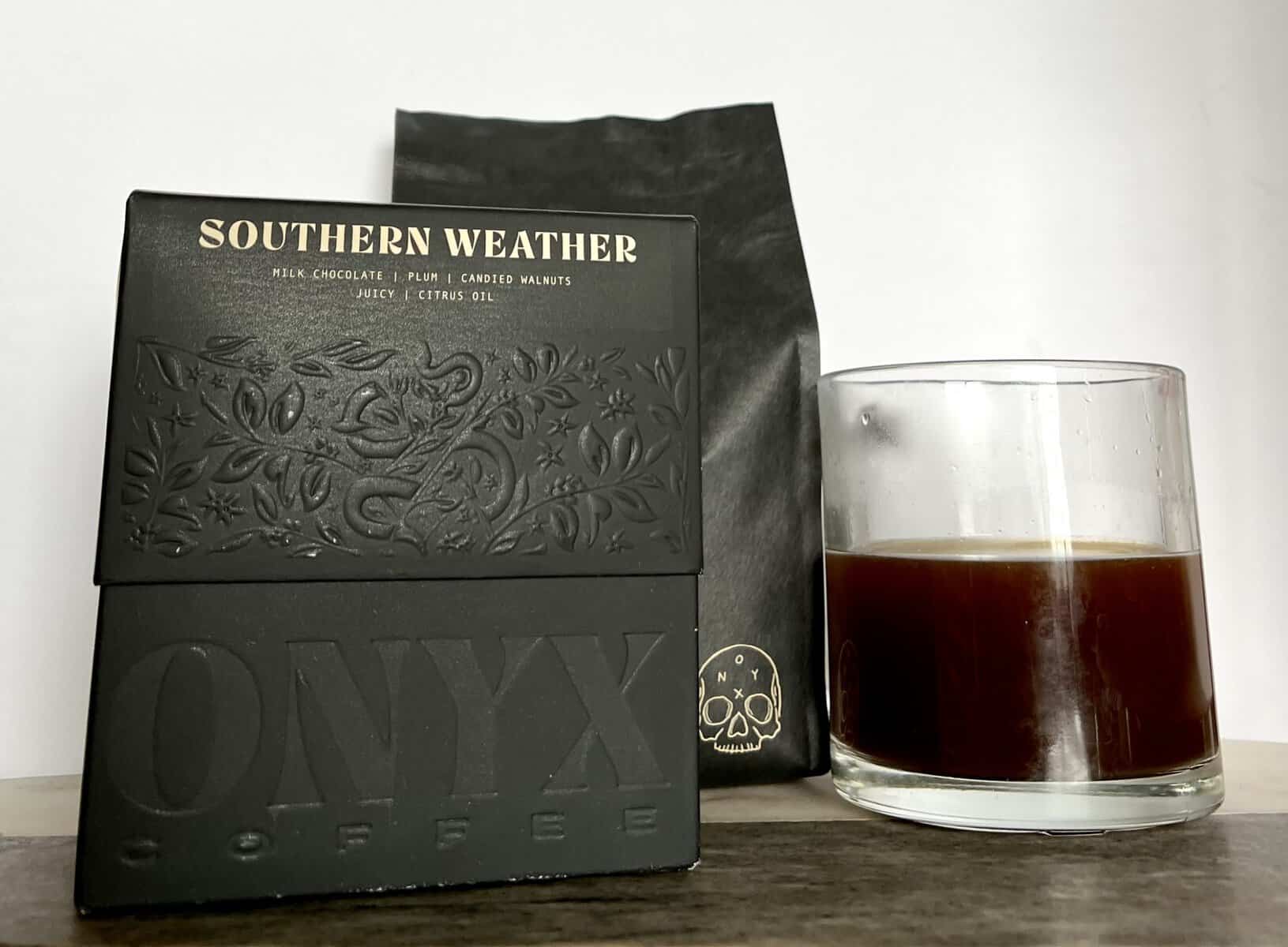 packaging-of-Onyx-Coffee-Lab-Southern-Weather-coffee-stands-next-to-a-brewed-cup-of-coffee-scaled